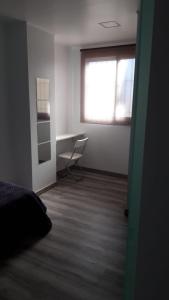 1 dormitorio con cama, escritorio y ventana en Jazmines, en Santiago de la Ribera