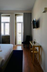 Cette chambre comprend un lit et un bureau. dans l'établissement ó Poboa Guesthouse, à Póvoa de Varzim