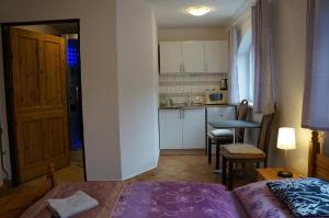 Cet appartement comprend une chambre avec un lit et une cuisine avec une table. dans l'établissement Penzion Kutil Trojanovice, à Frenštát pod Radhoštěm