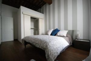 ein Schlafzimmer mit einem Bett und einer gestreiften Wand in der Unterkunft Tabacchi Luxury apartment in Lucca historical center near toll Parking in Lucca