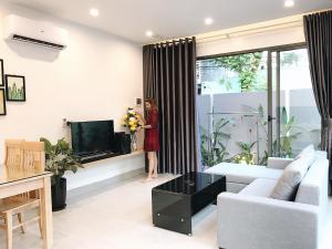 a woman is standing in a living room at Mưa House in Danang