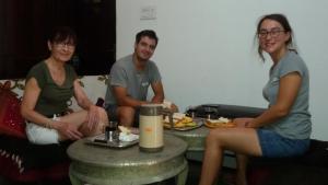 a group of three people sitting around a table with food at Hotel Vacation in Jaipur