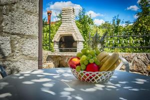 un bol de fruta en una mesa con chimenea de piedra en Holiday Home Veli Brgud, en Jurdani