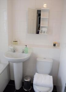 a white bathroom with a toilet and a sink at 3 Bedroom-Kelpies Serviced Apartments Burns in Falkirk