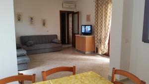 een woonkamer met een bank en een televisie bij Casa Alice in Budoni