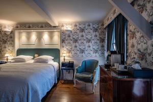 a bedroom with a bed and a chair and a desk at Hotel De Orangerie by CW Hotel Collection - Small Luxury Hotels of the World in Bruges