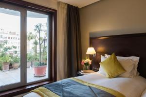 a bedroom with a bed and a large window at Le Diwan Hotel Rabat - MGallery Collection in Rabat