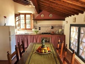 een keuken met een tafel met een fruitschaal erop bij Podere Casato in Montespertoli