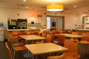 a school cafeteria filled with tables and chairs at ibis budget Brugge Centrum Station in Bruges