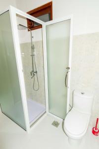 a white bathroom with a shower and a toilet at Turtle Paradise Villa in Kosgoda