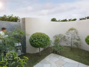 un jardín con una pared blanca y plantas en Tiger Palace Resort, en Bhairāhawā