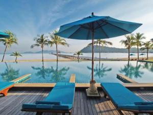 uma piscina com cadeiras azuis e um guarda-sol em Point of view condos, tranquility bay, koh chang em Ko Chang