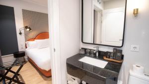 a bathroom with a sink and a mirror and a bed at Soho Boutique Opera in Madrid +51 photos