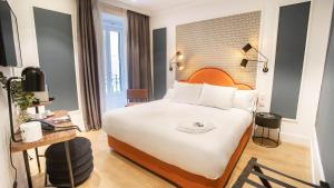 a hotel room with a large bed and a desk at Soho Boutique Opera in Madrid