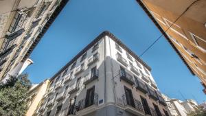 a tall white building with balconies on a street at Soho Boutique Opera in Madrid