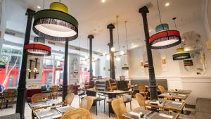 a restaurant with tables and chairs and lights at Soho Boutique Opera in Madrid