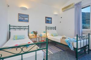 two beds in a room with a window at Villa Gaia - Scopello-Villas in Scopello