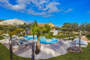 a swimming pool in a yard with palm trees at Villa Gaia - Scopello-Villas in Scopello +12 photos