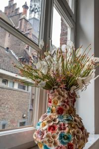 a vase filled with flowers sitting in a window at B&B Gracht 62 in Maastricht