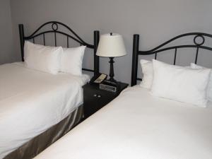 
a hotel room with two beds and two lamps at Barclay Hotel in Vancouver

