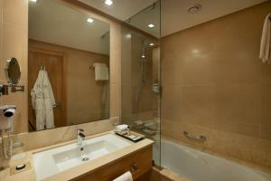 
a bathroom with a tub, sink and mirror at ODYSSEE Boutique Hotel Casablanca in Casablanca
