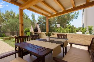 a patio with a table and chairs and a stove at Apartmani Gnjidic in Srima