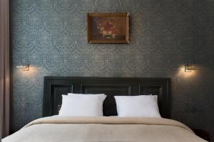 uma cama com duas almofadas e uma fotografia na parede em Boutique hotel Sint Jacob em Maastricht