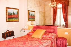 a bedroom with a red bed and a chair at Palazzo Odoni in Venice