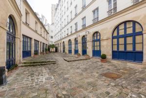 an alley between two buildings with blue doors at Veeve - À la Mode Retreat by the Seine in Paris