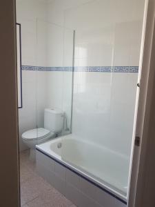 een badkamer met een bad, een toilet en een douche bij Las Belisas - Apartamentos in Arenal d'en Castell