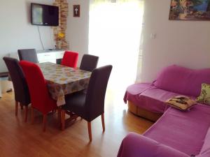 ein Wohnzimmer mit einem Tisch, Stühlen und einem Sofa in der Unterkunft Apartments Bor - 20m from the beach in Kraj