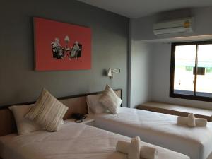 een hotelkamer met 2 bedden en een raam bij Chalong Sea Breeze in Chalong 