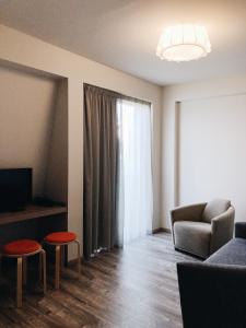 a living room with a couch and two stools at Banja Kulaši in Kulaši