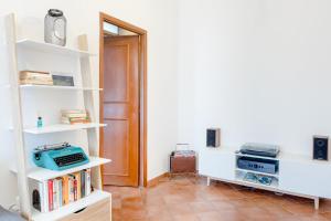 a room with white shelves with books and a door at Vinylogy Apt in Rome
