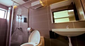 a bathroom with a toilet and a sink and a mirror at Hotel Setia in Kluang