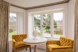 a living room with two chairs and a table and a window at Heacham Manor Hotel in Hunstanton