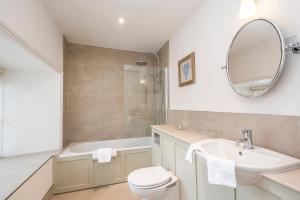 a bathroom with a sink and a toilet and a mirror at Heacham Manor Hotel in Hunstanton