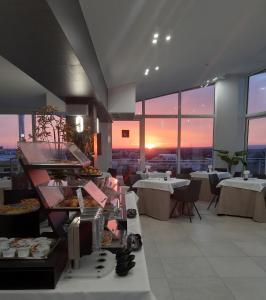 restauracja z bufetem z jedzeniem i stołami w obiekcie Grieco Business & Spa Hotel w mieście Cerignola