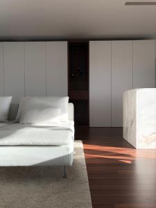 een slaapkamer met een wit bed en een houten vloer bij VMO Apartment in Vila do Conde +10 foto's