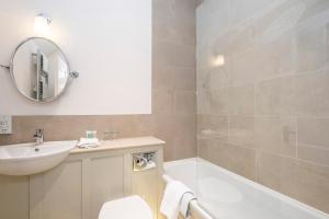 a bathroom with a tub and a sink and a mirror at Heacham Manor Hotel in Hunstanton
