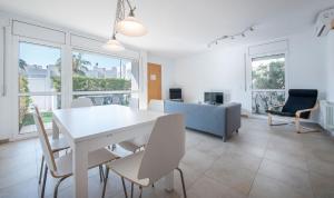 uma sala de jantar branca com uma mesa e cadeiras brancas em Eulalia Apartments, TarracoHomes em Altafulla
