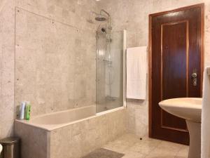 een badkamer met een douche, een bad en een wastafel bij VMO Apartment in Vila do Conde
