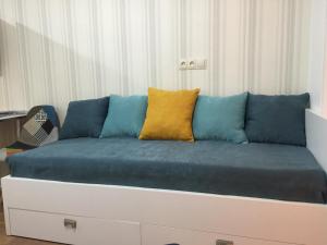 a blue couch with a yellow pillow on it at City Center Apartment 2 in Tbilisi City