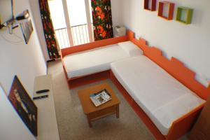 ロザスにあるAgi Sant Antoniのベッド2台とテーブルが備わる小さな客室です。