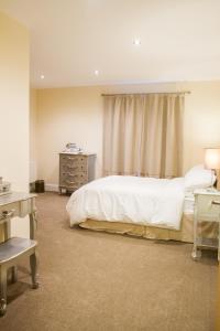 a bedroom with a bed and a dresser and a window at Fair Oak House Exeter Airport in Exeter