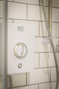 a shower in a bathroom with white tiles at Fair Oak House Exeter Airport in Exeter