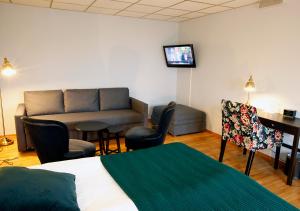 ein Hotelzimmer mit einem Bett, einem Sofa und einem Schreibtisch in der Unterkunft Rasta Hallandsåsen in Båstad