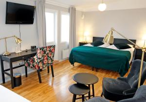 ein Hotelzimmer mit einem Bett, einem Schreibtisch und einem Stuhl in der Unterkunft Rasta Hallandsåsen in Båstad