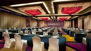 a conference room with tables and chairs and a stage at Pullman Dalian in Dalian +43 photos