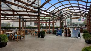 a restaurant with tables and chairs under a glass roof at Pullman Dalian in Dalian